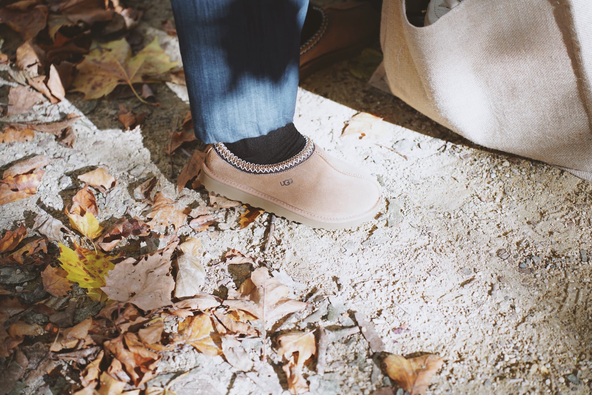 Détail des chaussures beiges dans les feuilles d'automne