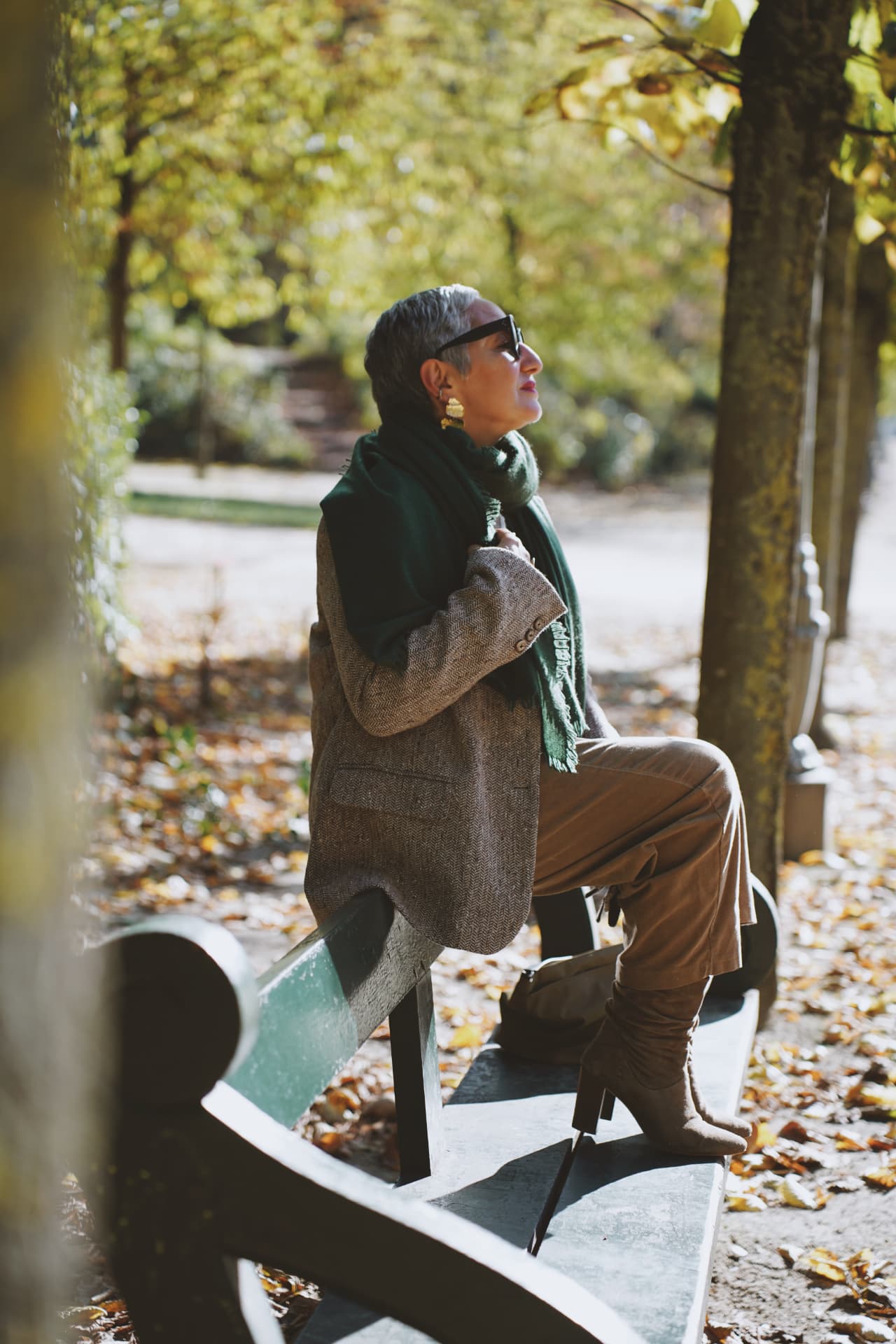 Profil sur un banc, écharpe verte et blazer en tweed