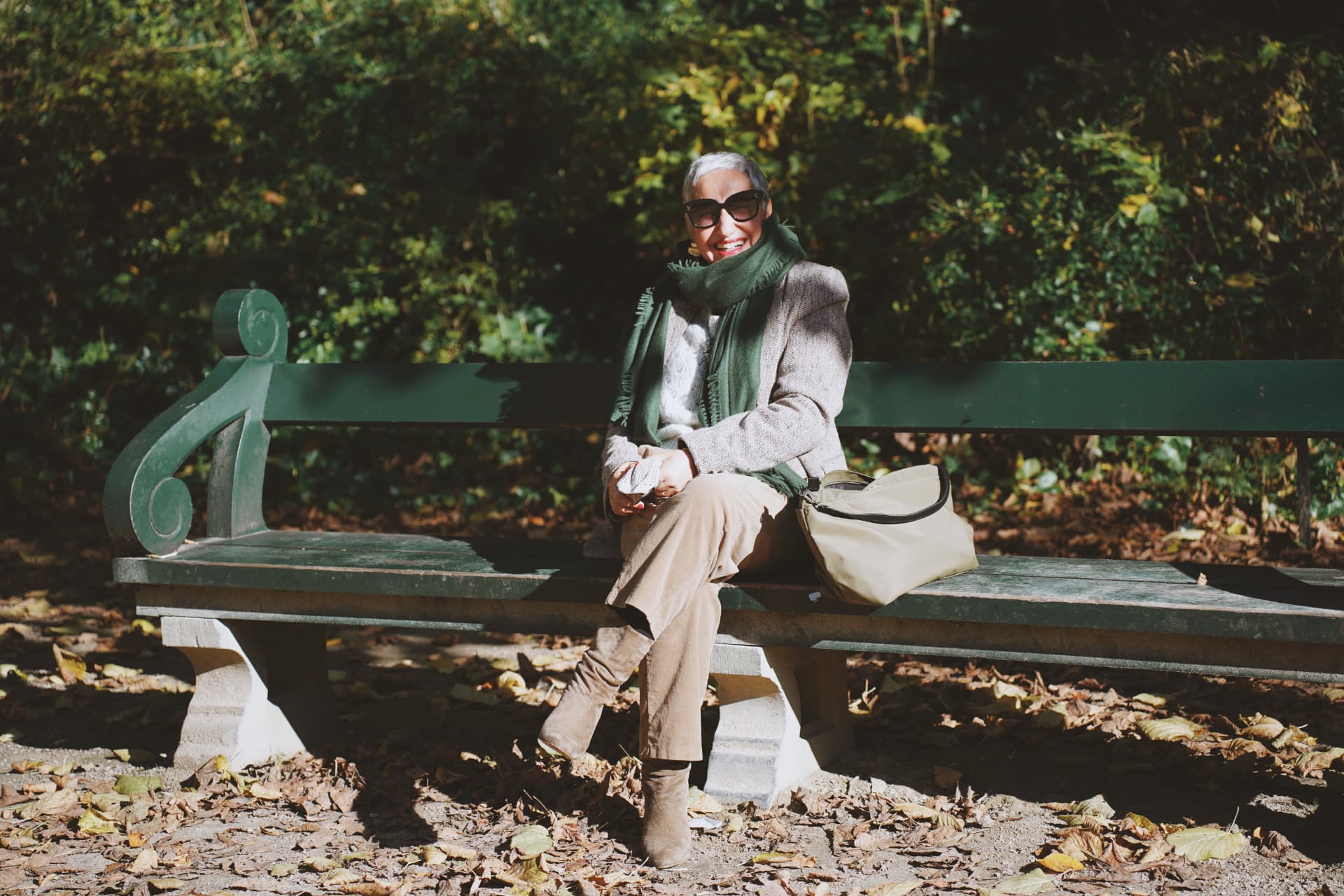 Sur le banc vert, écharpe verte, blazer en tweed et sac beige