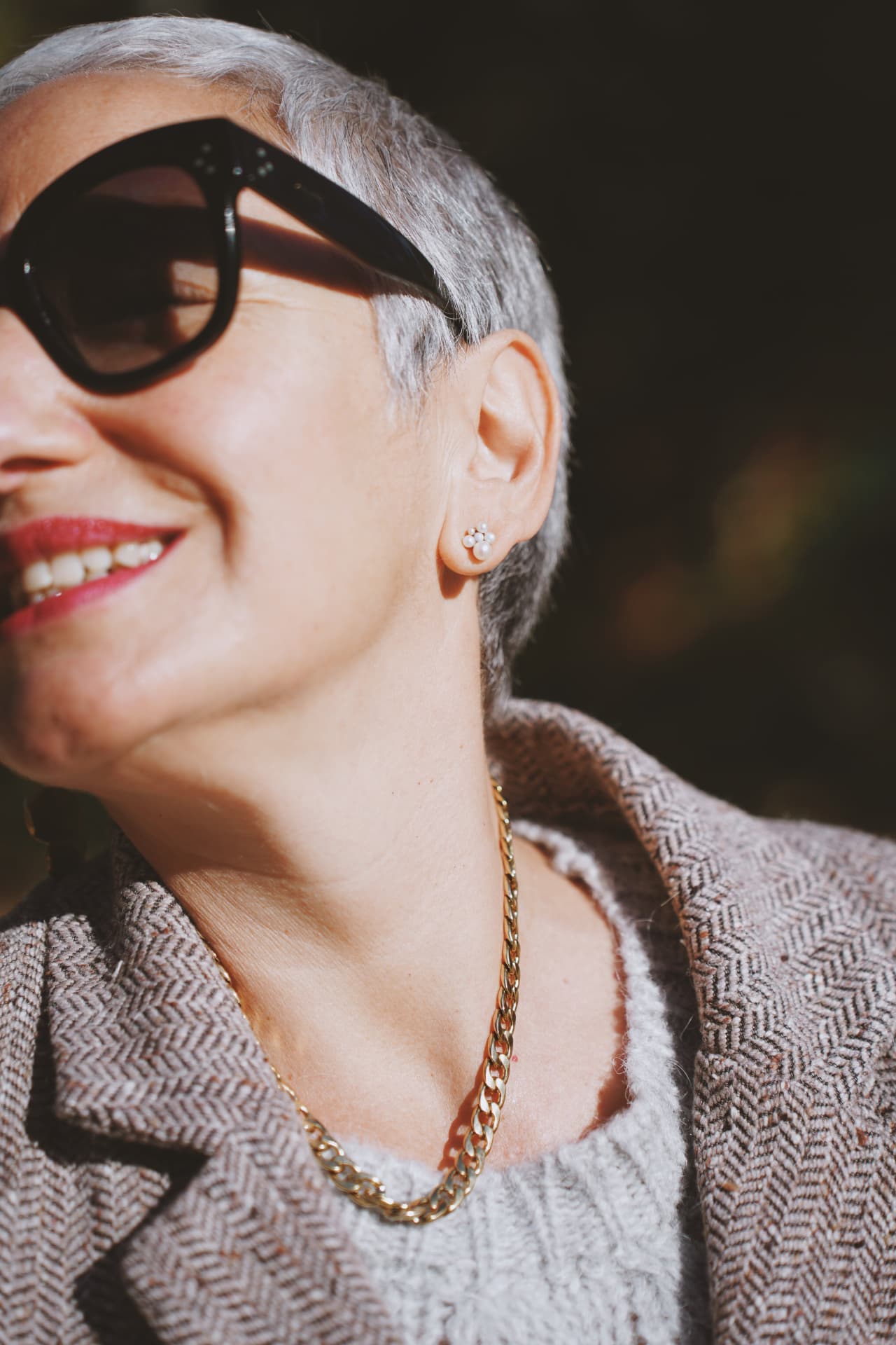 Détail du profil au soleil, chaîne dorée et blazer en tweed
