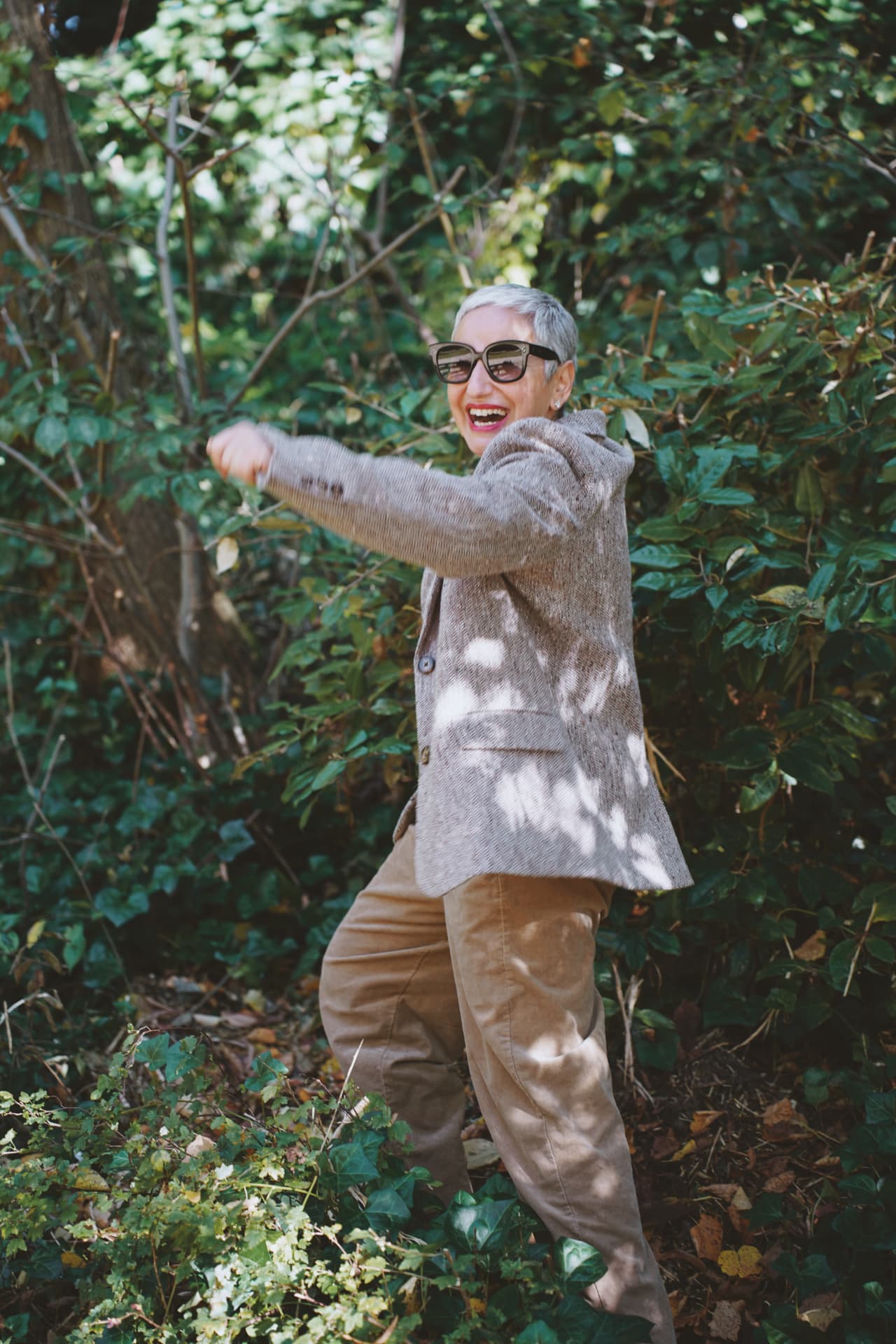 Bras tendu dans la végétation, blazer en tweed