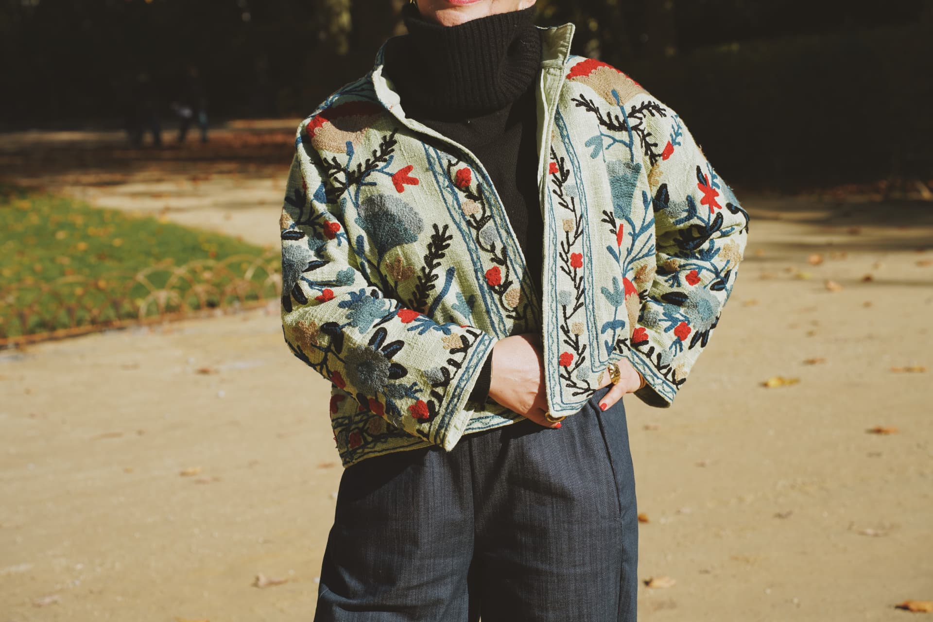 Détail de la veste brodée florale portée sur un col roulé noir