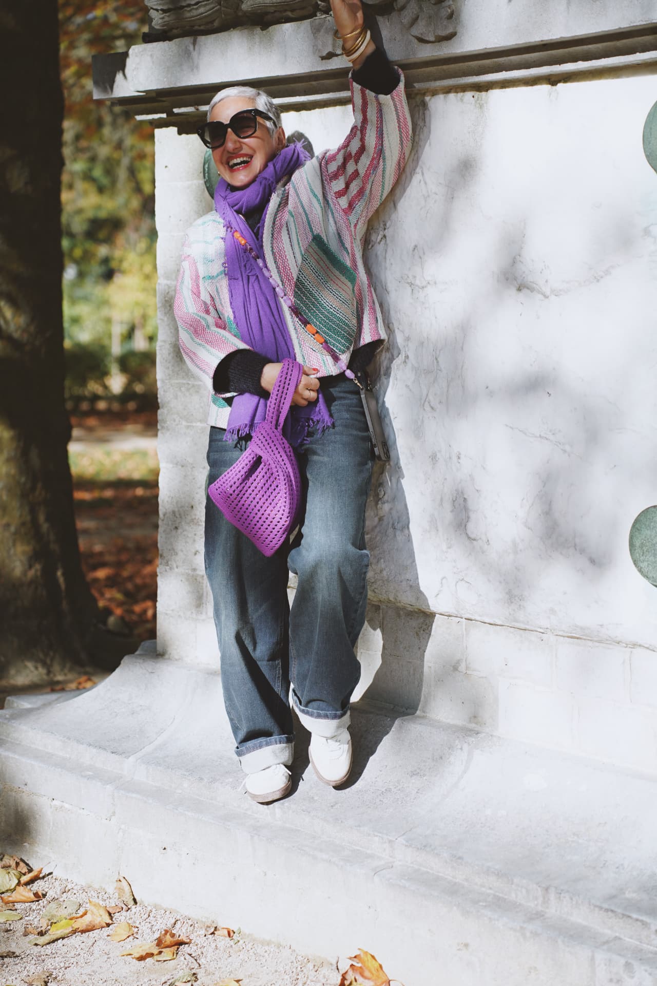 Sur les marches de pierre, gilet rayé pastel et sac violet