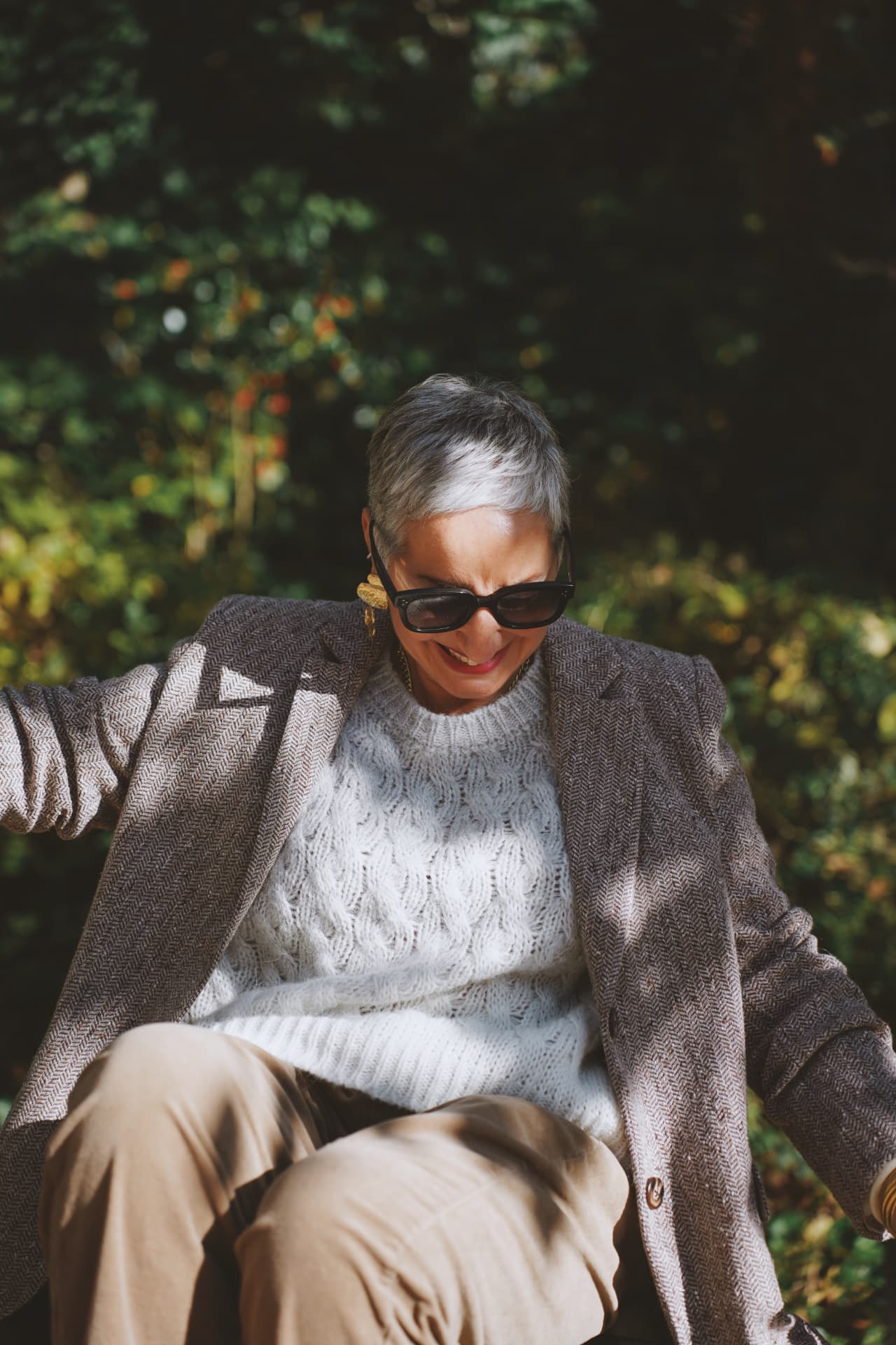 Bras ouverts, blazer en chevrons et pull crème