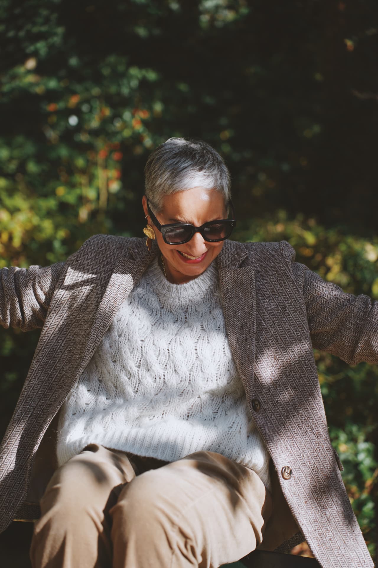 Pull tricoté blanc sous un blazer en chevrons, lumière rasante