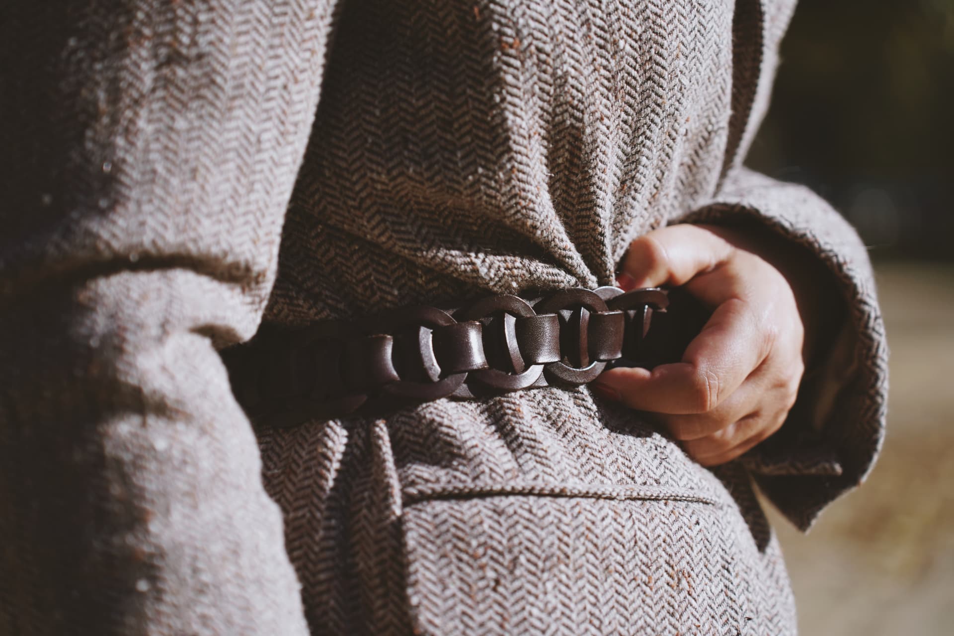 Détail de la ceinture en cuir tressé sur le blazer en tweed