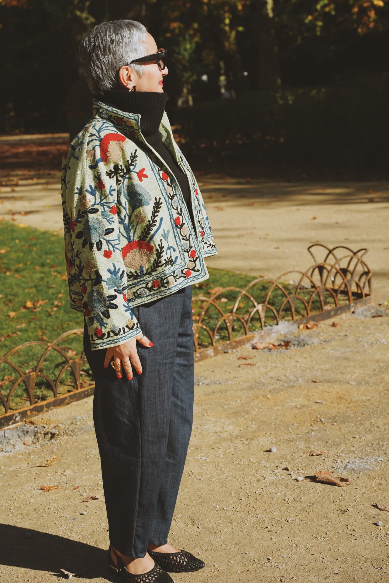 De profil dans l'allée, veste brodée florale et col roulé noir
