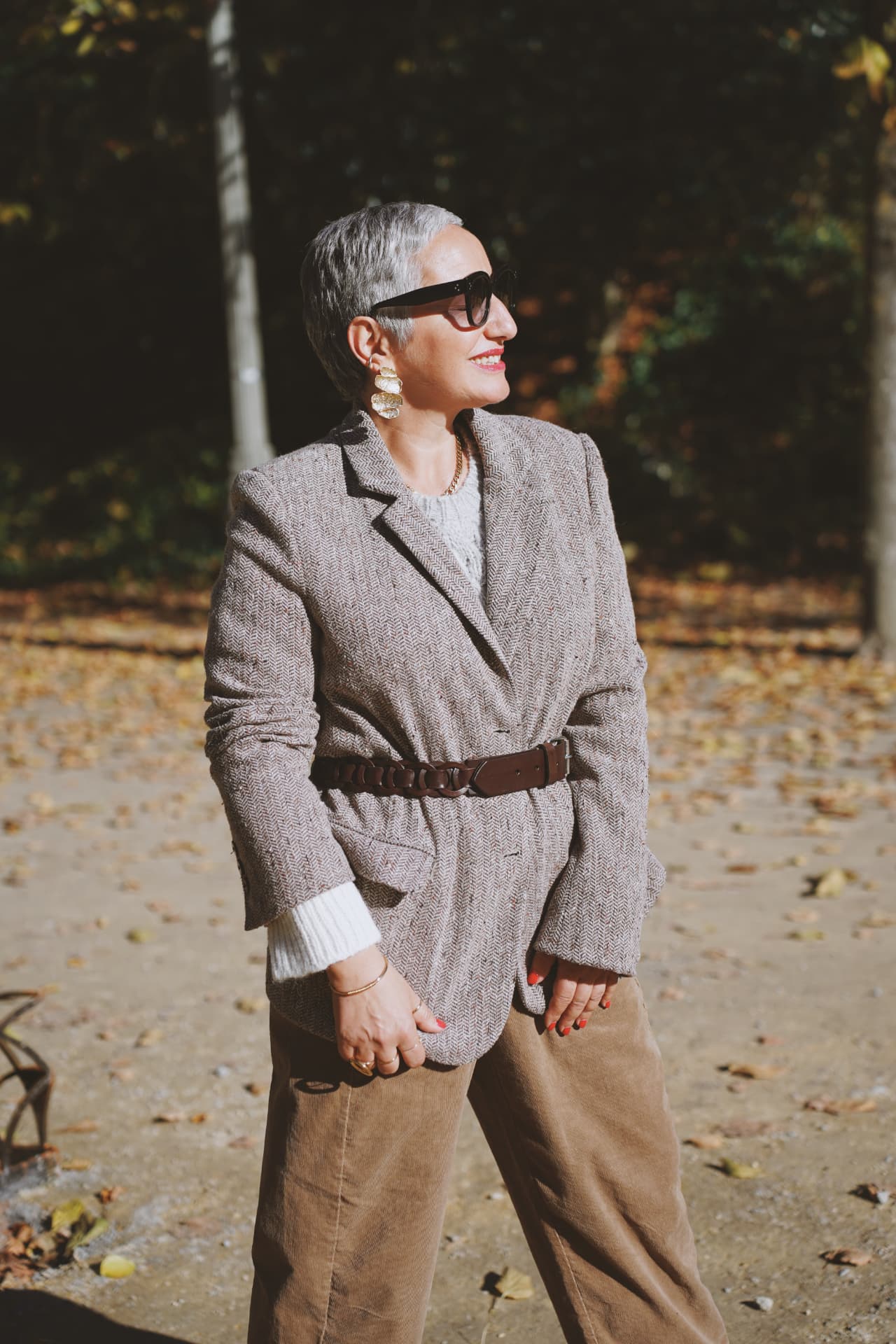 Blazer en tweed ceinturé et boucles d'oreilles dorées